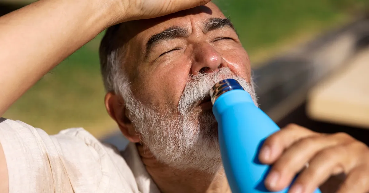 Anziano in difficoltà per il caldo estremo che beve acqua all'aperto — kit emergenza ondata di calore Italia